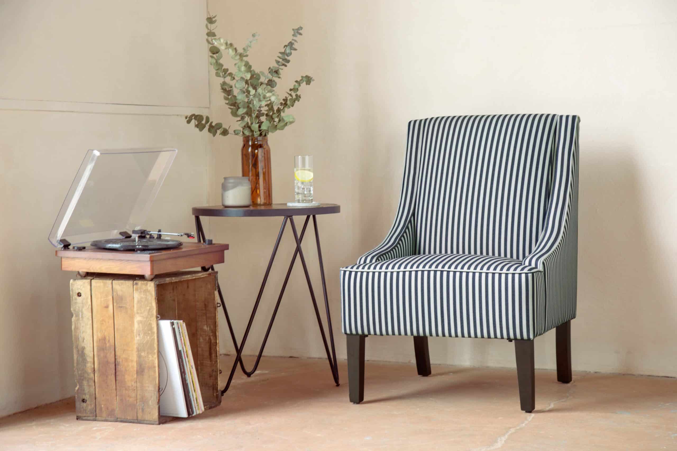 A Wovenbyrd Navy Stripe Swoop Arm Accent Chair makes adds coziness to a living space.